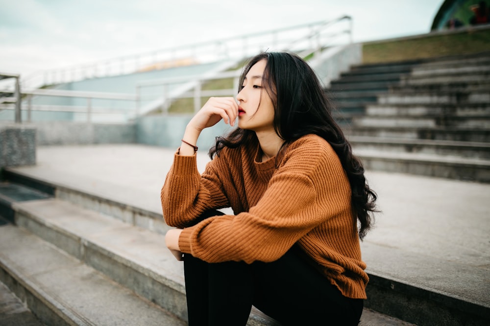 woman wearing brown sweater holding lips